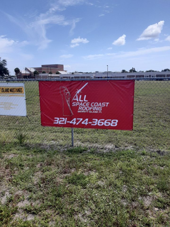 Red All Coast Plumbing sign in a grassy lot under a blue sky, with phone number 321-474-3668.