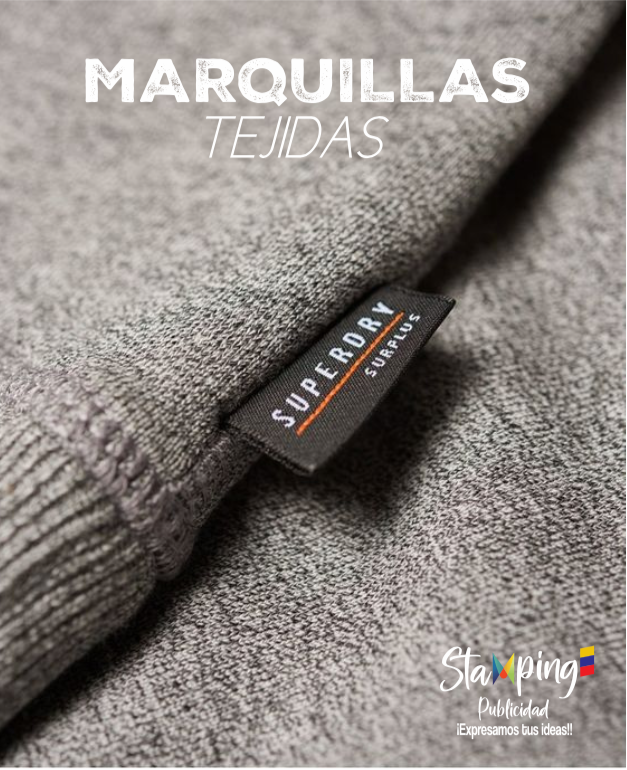 Primer plano de tela de punto gris con etiqueta “Superdry” y texto superpuesto “Maravilas Tejidas”.