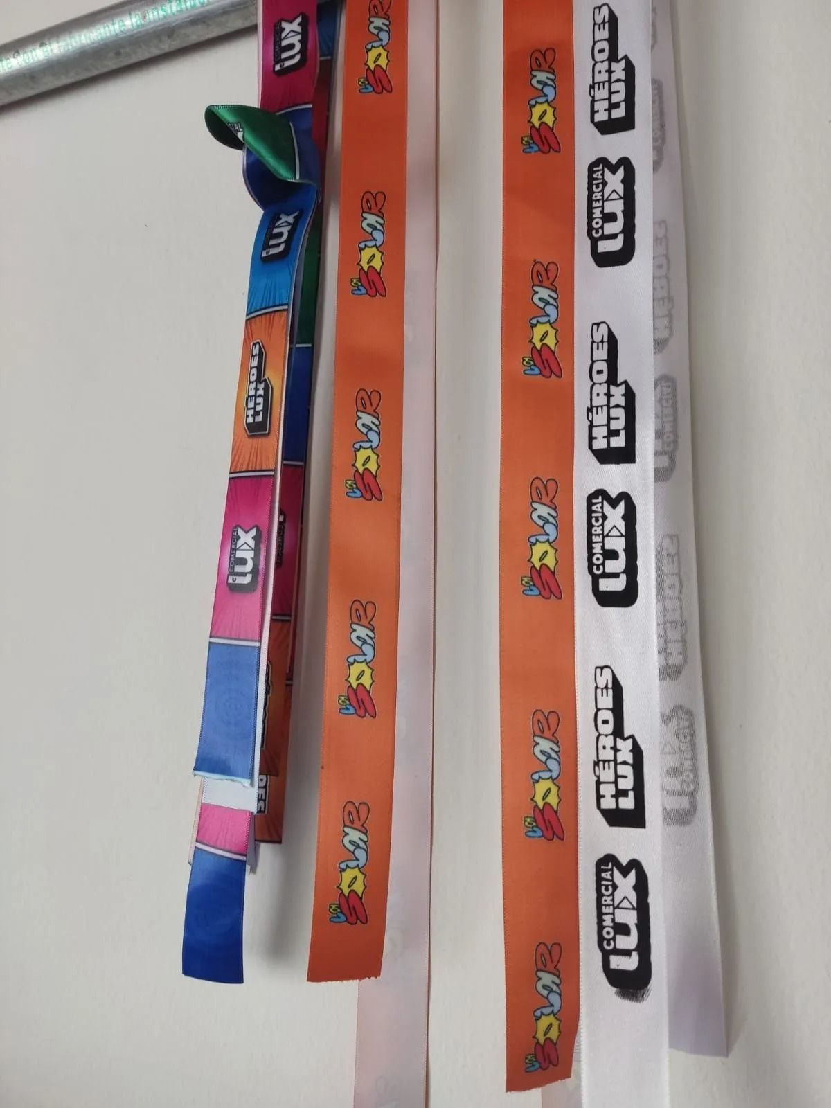 Tres tiras de tela de colores con estampados impresos, dispuestas en diagonal sobre una superficie gris.