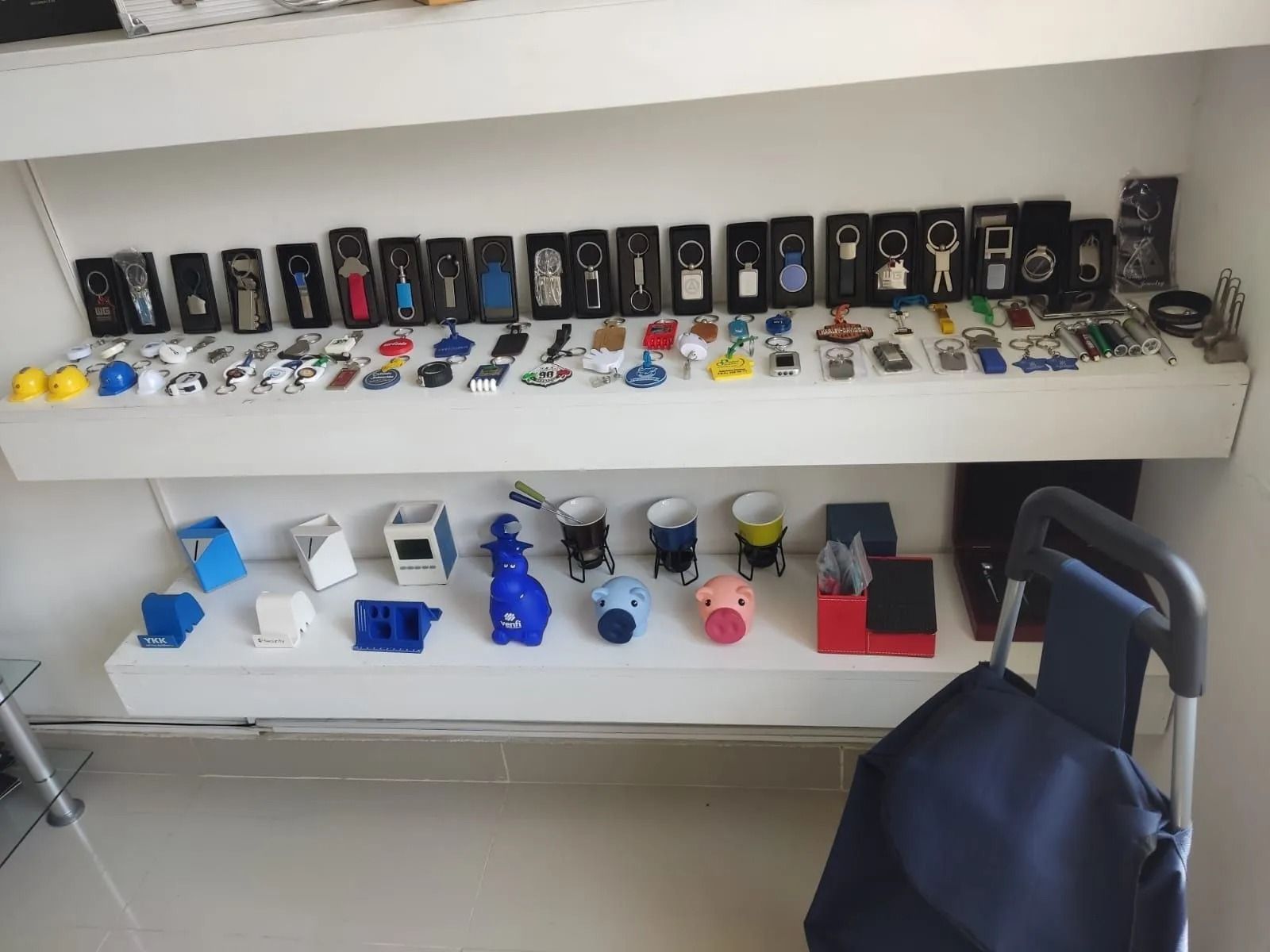 Estanterías que exhiben numerosos coches de juguete pequeños y contenedores, con una bolsa oscura en primer plano.