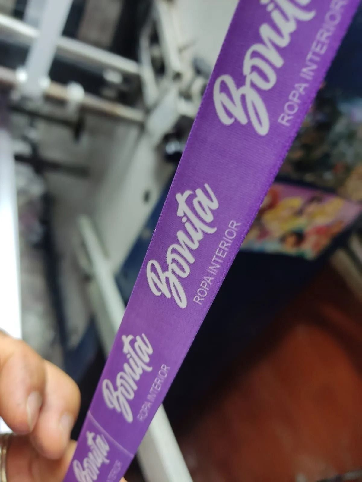 Mano sosteniendo una correa morada con la palabra