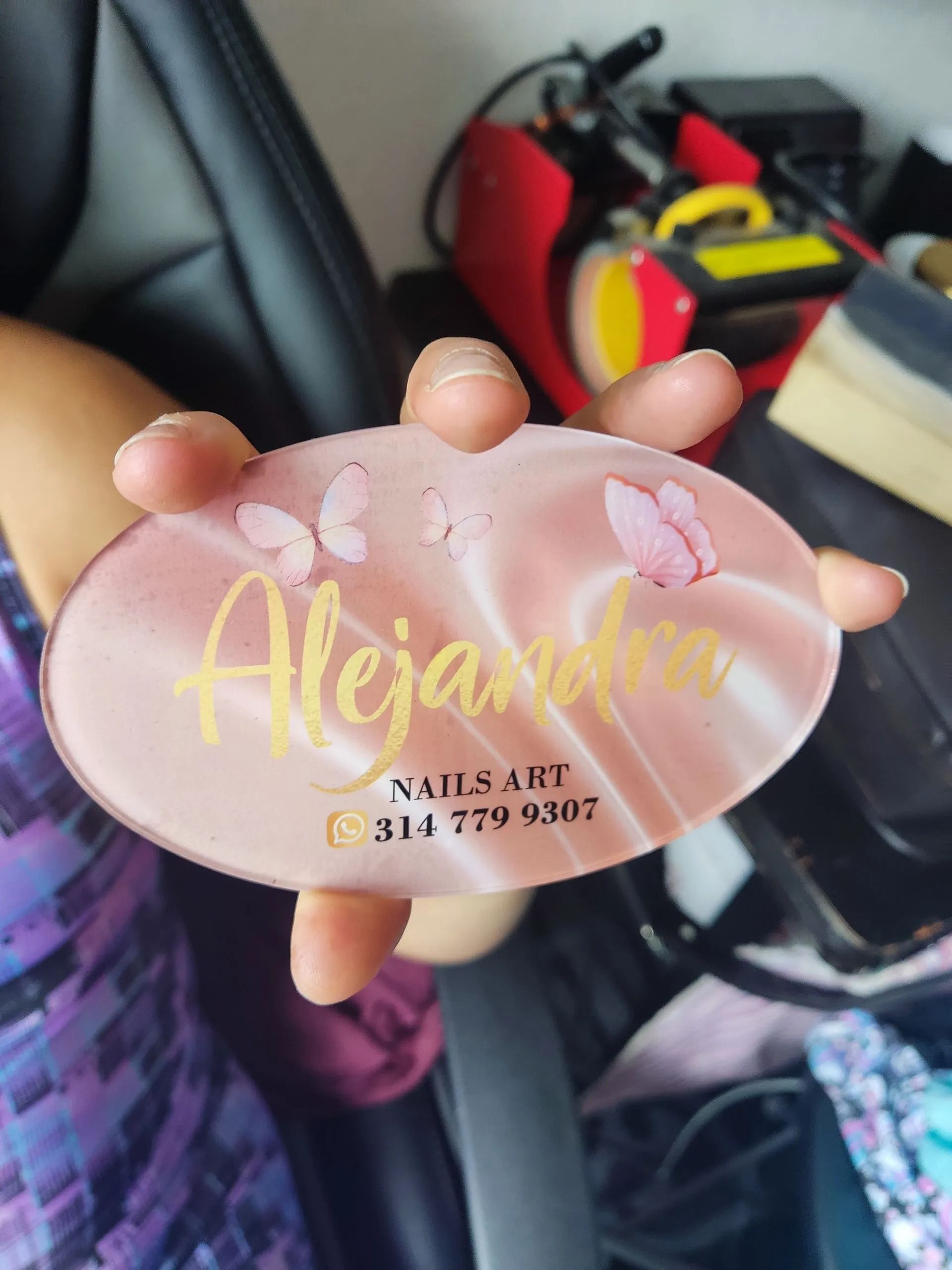 Una placa ovalada rosa con mariposas y el nombre