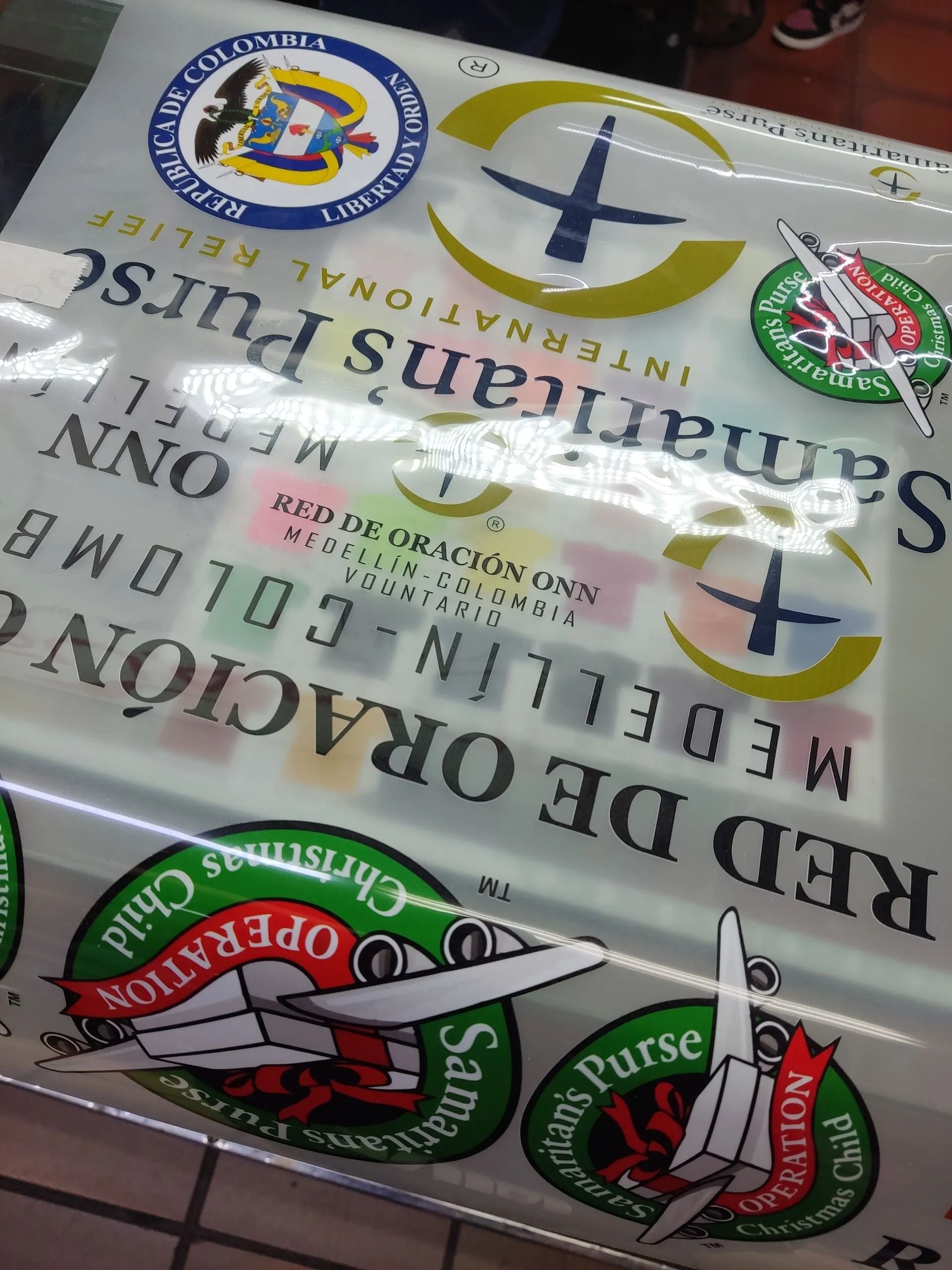 Surtido de vasos de papel y fundas para vasos del Red Deer College con logotipo y texto en verde y blanco.