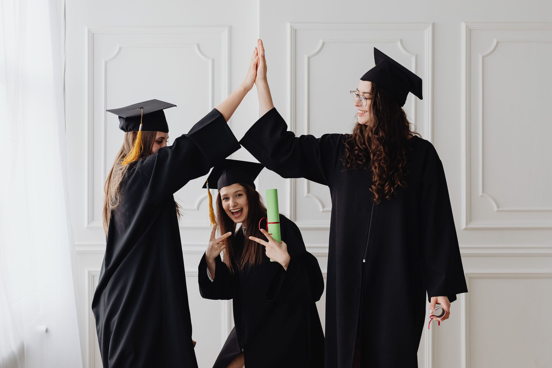 Three graduates in caps and gowns.