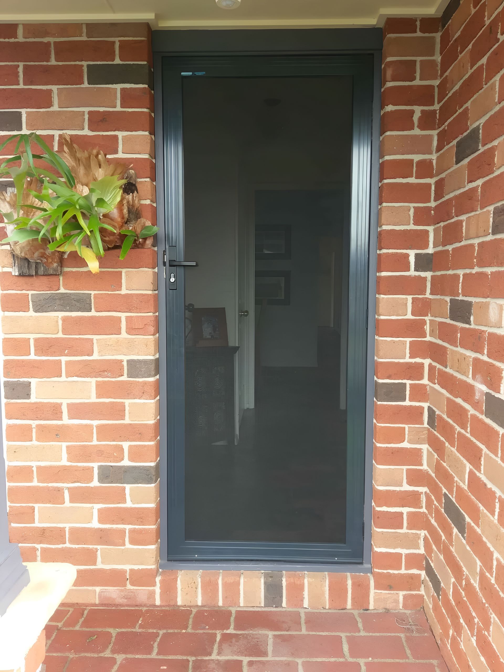 Screen Door in Gray Frame Set in Brick Wall — LeSands Screens & Blinds Moss Vale Pty Ltd in Moss Vale, NSW