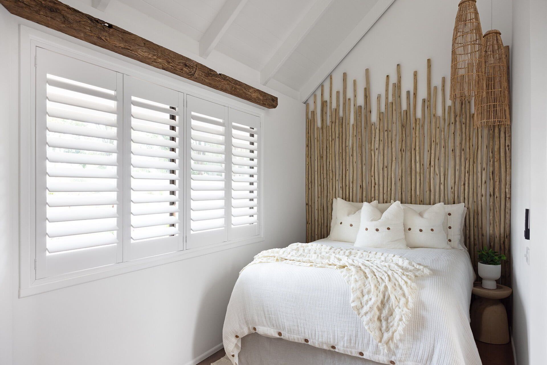 Bedroom With White Shutters, Bed, and Bamboo Wall Backdrop — LeSands Screens & Blinds Moss Vale Pty Ltd in Bowral, NSW