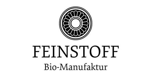 Logo der Feinstoff Bio-Manufaktur mit schwarzem kreisförmigem Emblem und Serifenschrift auf weißem Hintergrund