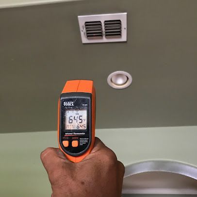 Handheld infrared thermometer aimed at a ceiling vent, showing 64.5°F.