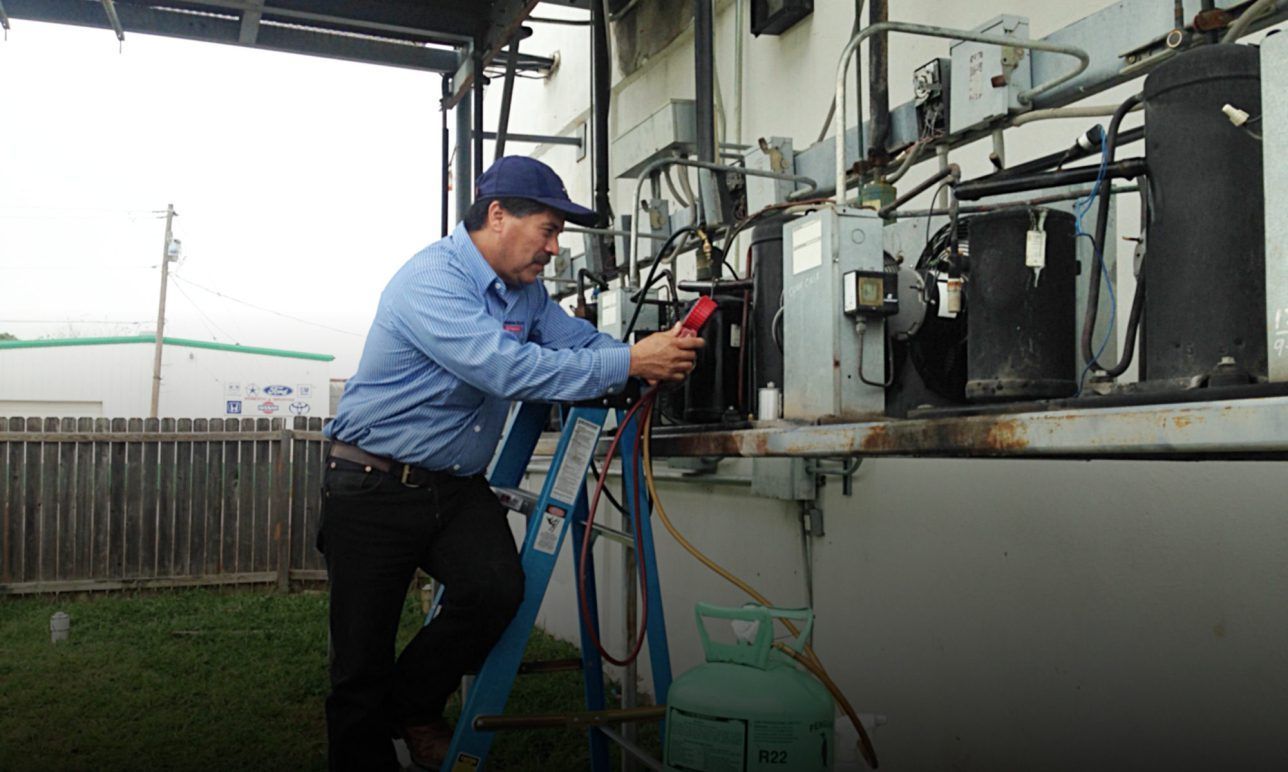 Technician inspecting electrical equipment with a tool at an outdoor industrial panel