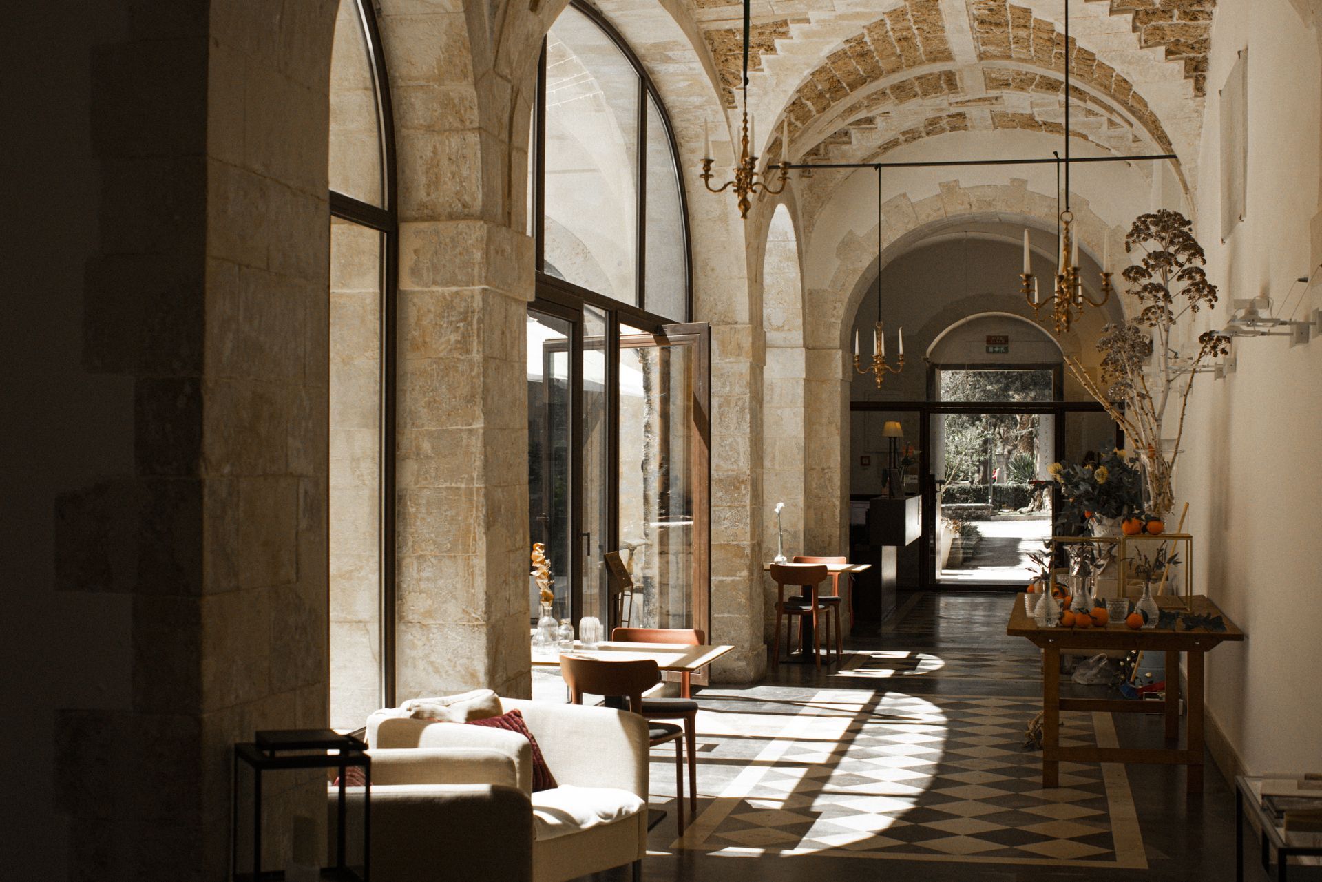 Un lungo corridoio con molte finestre e mobili in un edificio | Antico Convento dei Cappuccini | Ragusa Ibla | Sicilia