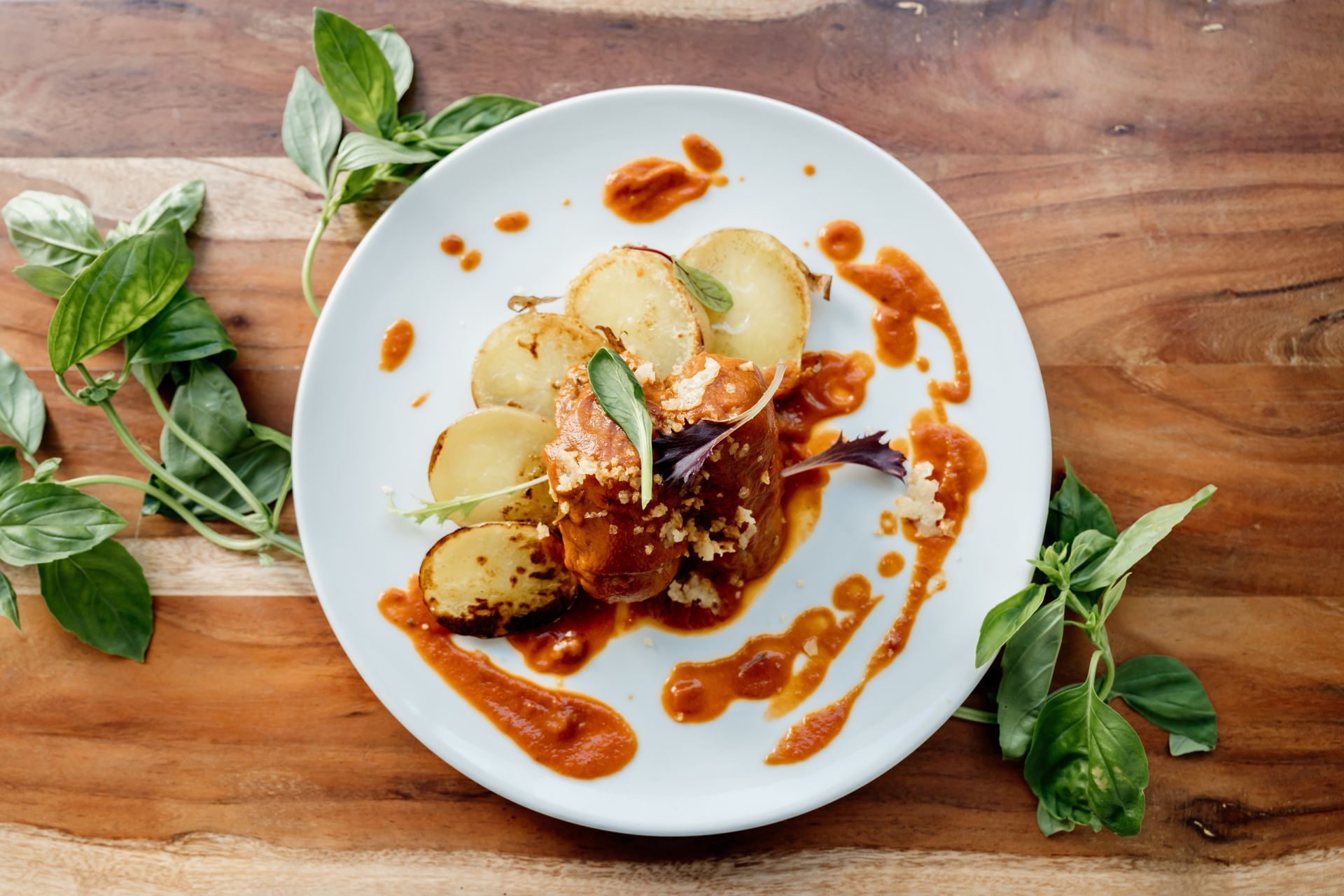 Un piatto con patate e salsa su un tavolo di legno. Osteria dei Frati | Il Cenobio. Antico Convento di Ragusa | Sicilia