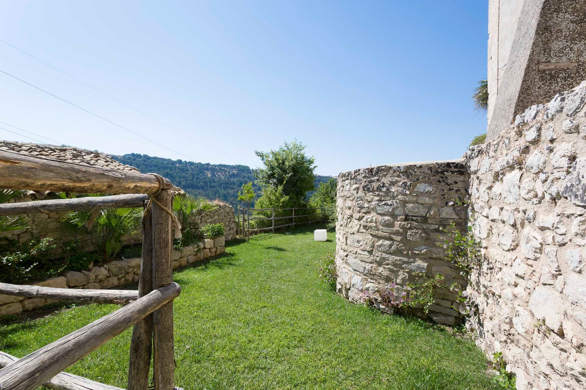 Una staccionata in legno circonda un rigoglioso prato verde | Antico Convento dei Cappuccini | Ragusa Ibla | Sicilia