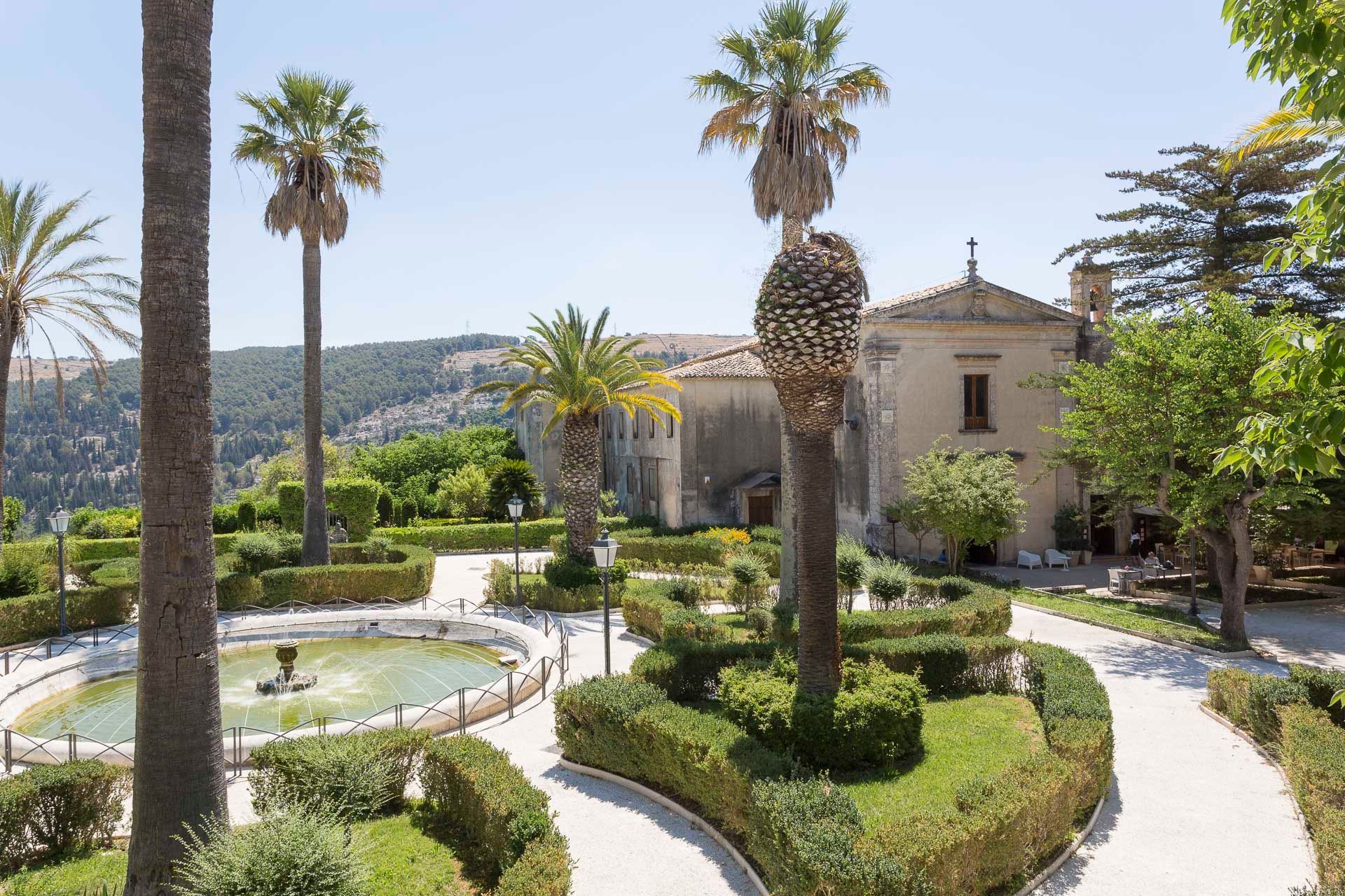 C'è una fontana al centro dei giardini circondata da palme e vialetti per rilassanti passeggiate | Antico Convento