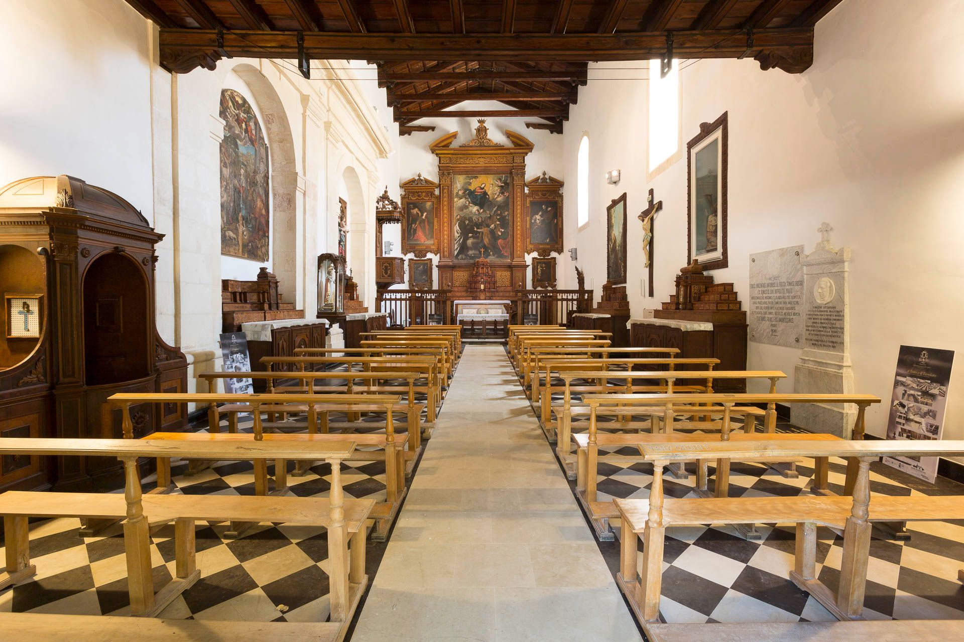 L'interno della chiesa di sant'Agata con panche in legno e pavimento a scacchi | Antico Convento dei Cappuccini | Ragusa Ibla