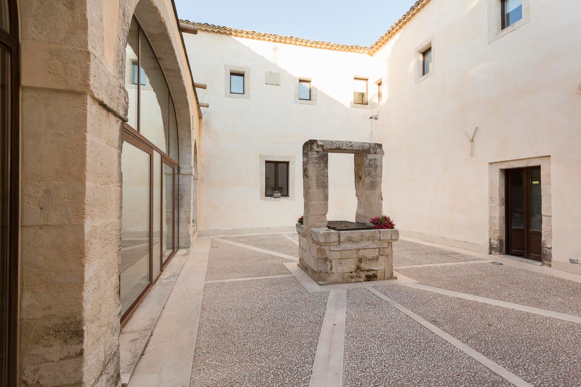 Un cortile con al centro un pozzo in pietra | Antico Convento dei Cappuccini | Ragusa Ibla | Sicilia