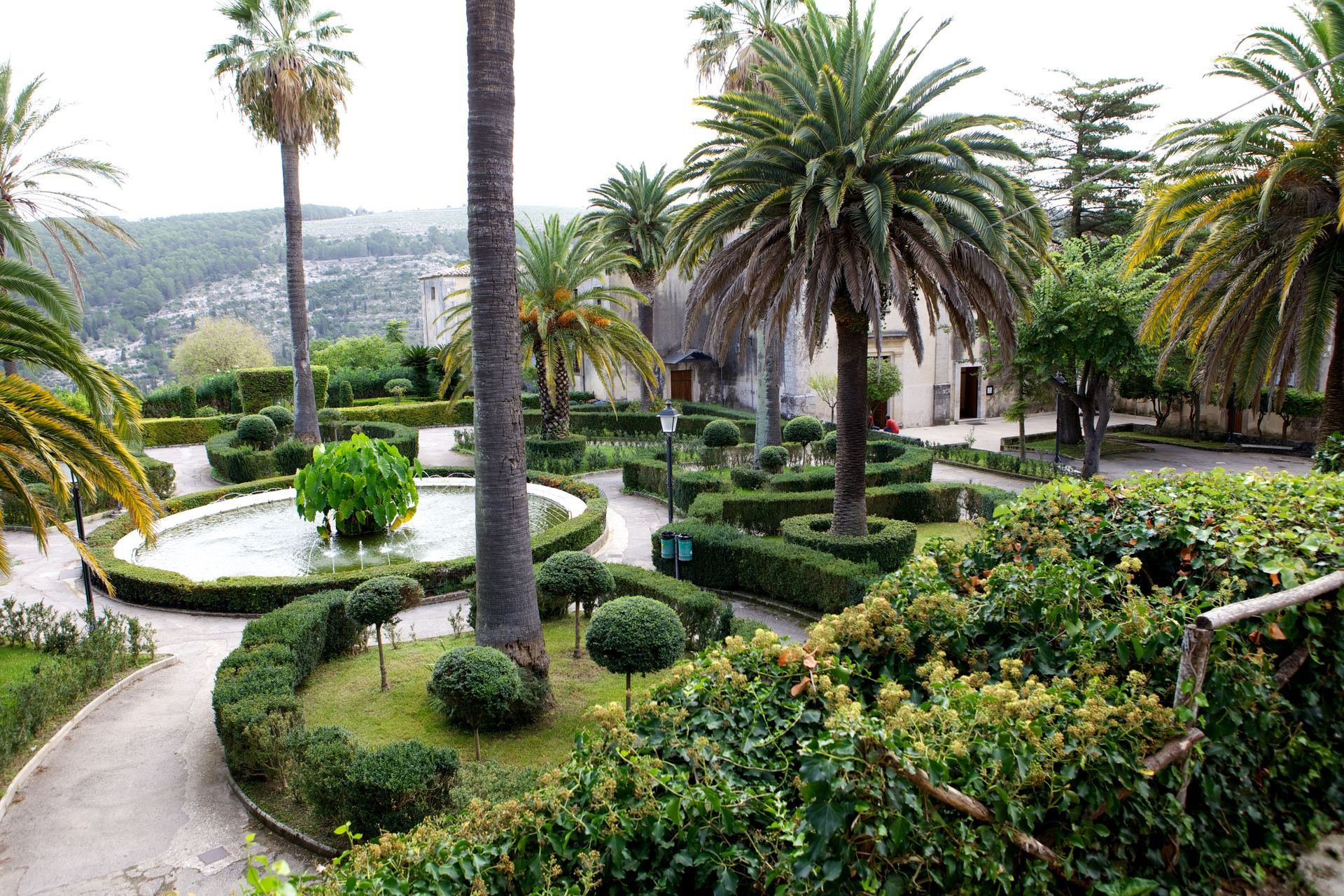 Un rigoglioso giardino verde con palme e cespugli | Antico Convento dei Cappuccini | Ragusa Ibla | Sicilia