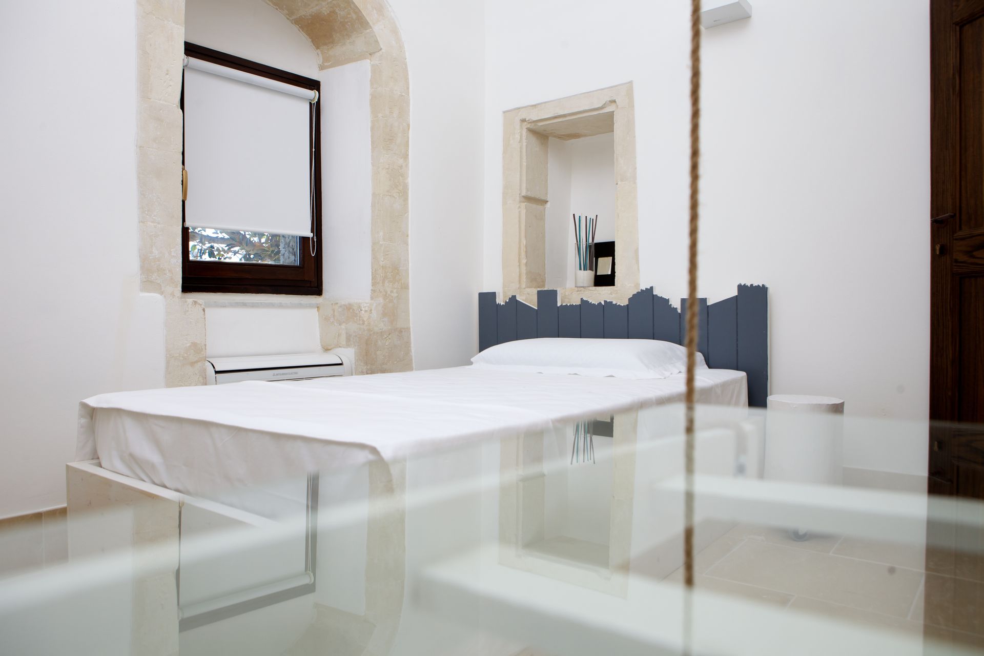 Una camera con un letto e un tavolo in vetro. Le stanze dell'Hotel Ritiro con Vista | Antico Convento dei Cappuccini | Ragusa