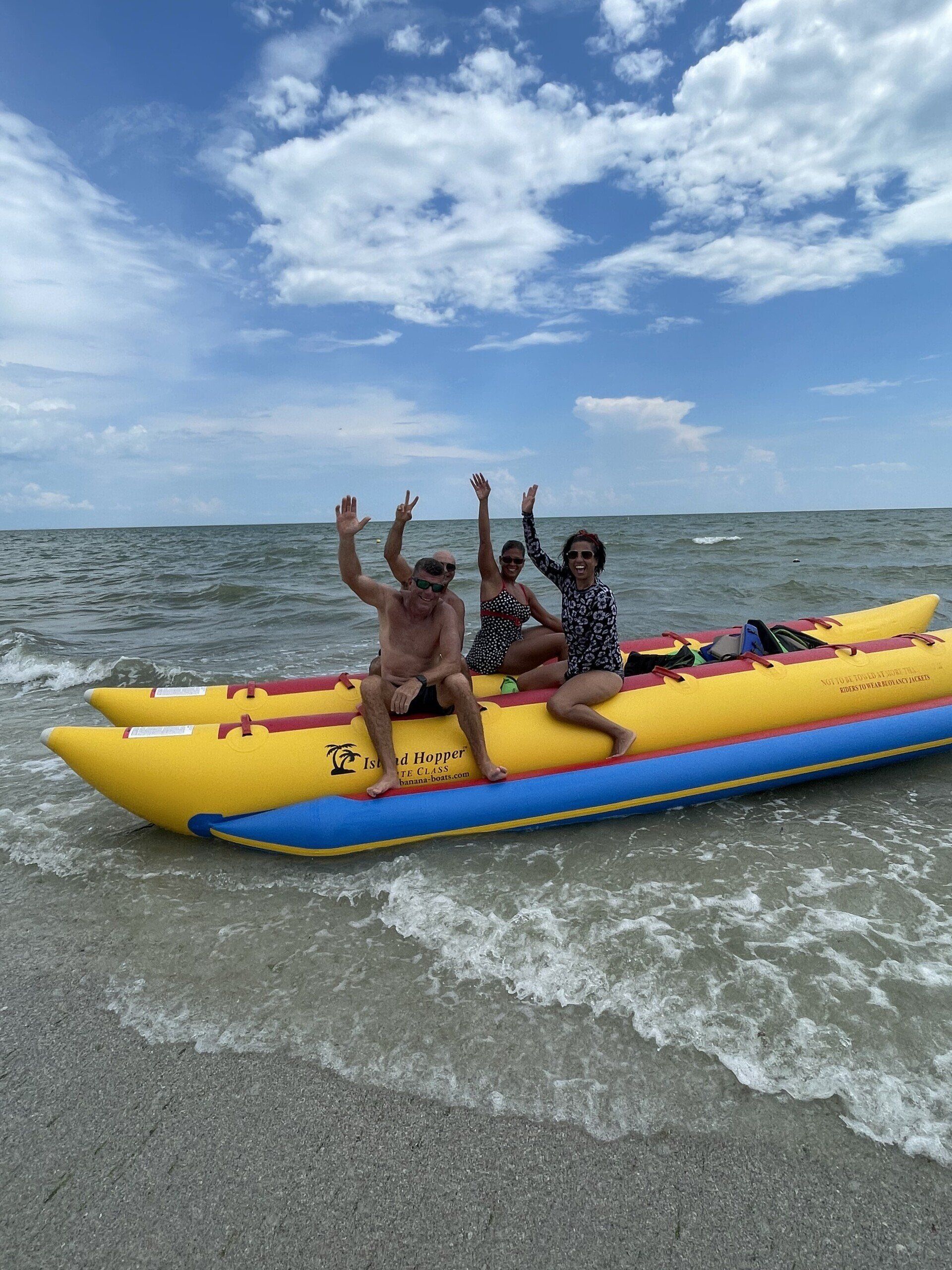 People waving while on a banana boat