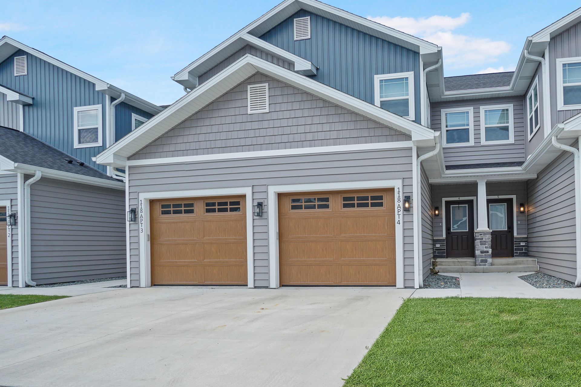 Modern townhouse exterior with double garage and small front lawn
