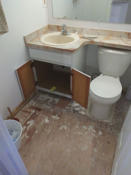 A bathroom with a toilet , sink and mirror