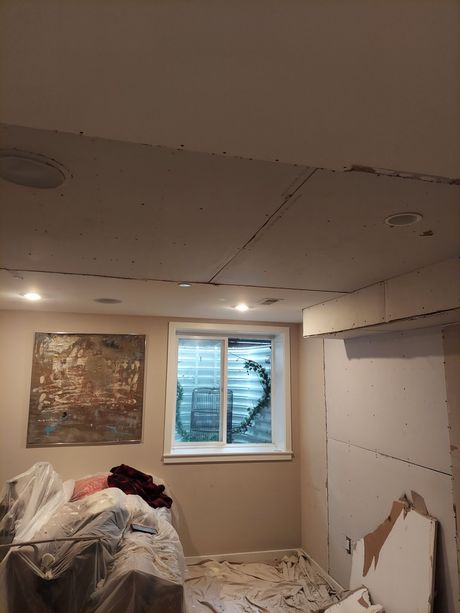 A room with a window and a painting on the wall.