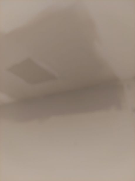A shadow of a person is cast on a white surface.