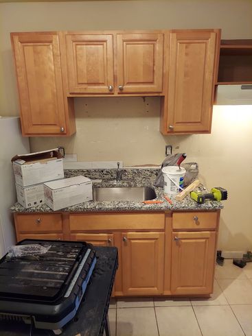 A kitchen with wooden cabinets and a stainless steel sink