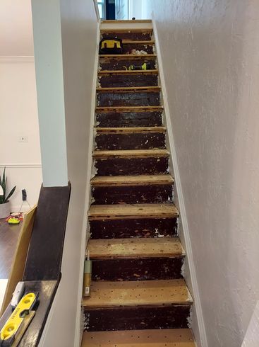 A staircase with a yellow level on the side of it