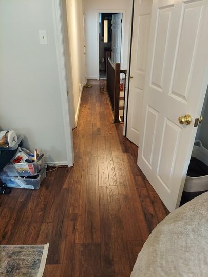 A hallway with hardwood floors and white doors in a house.