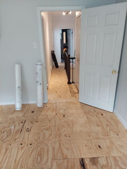 A room with a wooden floor and a door that is open.