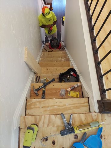 A man is working on a set of wooden stairs.