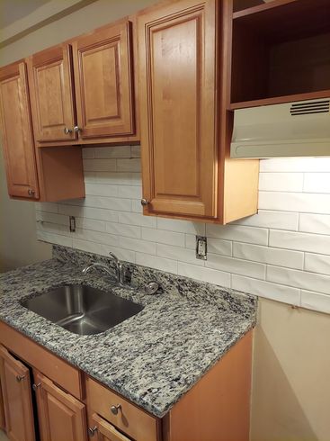 A kitchen with granite counter tops and wooden cabinets