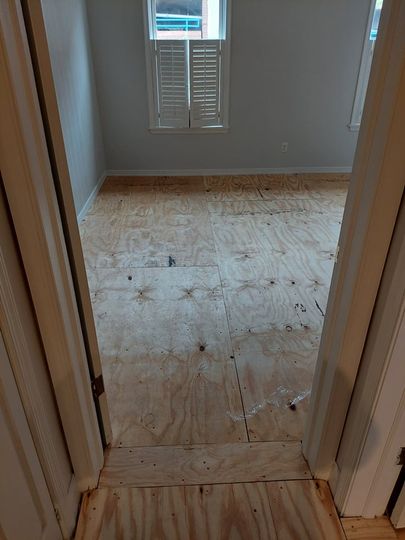 A room with a wooden floor and a window.