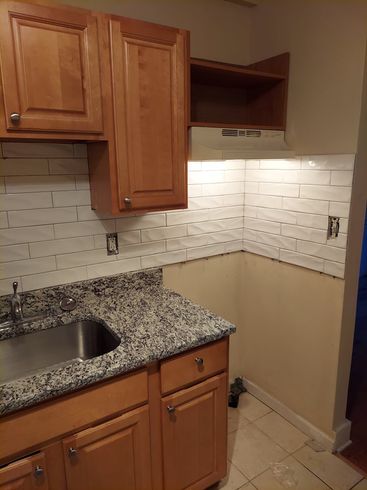 A kitchen with granite counter tops and wooden cabinets