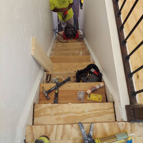 A man is working on a set of wooden stairs