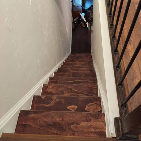 A set of wooden stairs with a metal railing