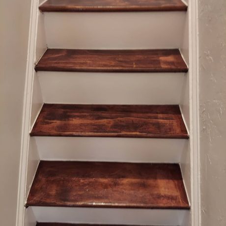 A close up of a set of wooden stairs with white trim.