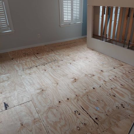A room with a wooden floor and shutters on the windows