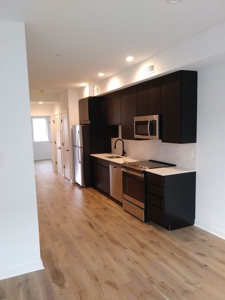 A kitchen with black cabinets and stainless steel appliances