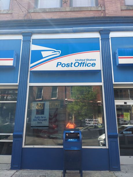 A post office with a blue mailbox in front of it