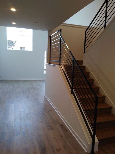 A staircase with a metal railing in an empty room