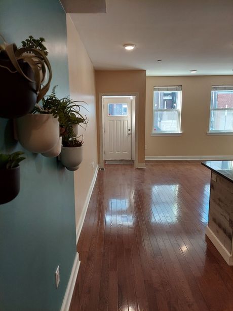 A hallway in a house with potted plants on the wall.