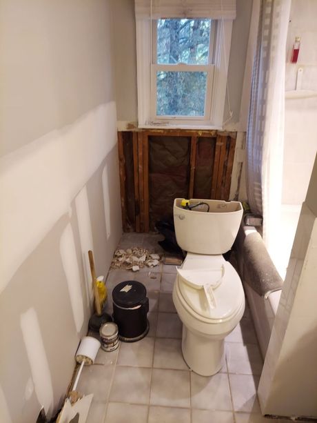 A bathroom with a toilet and a window in it