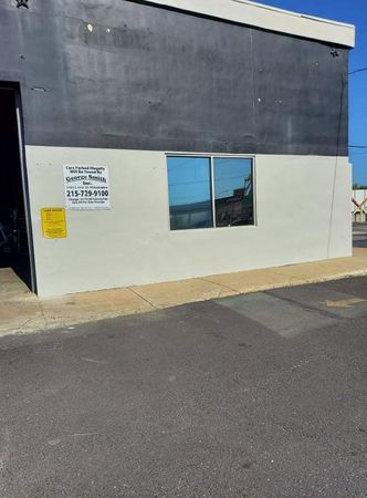 A black and white building with a window and a sign on the side of it.