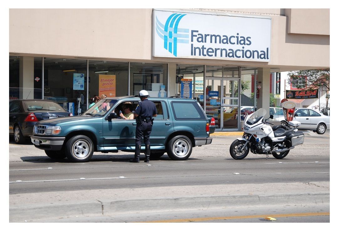 A motorcycle is parked in front of a farmacias internacional store