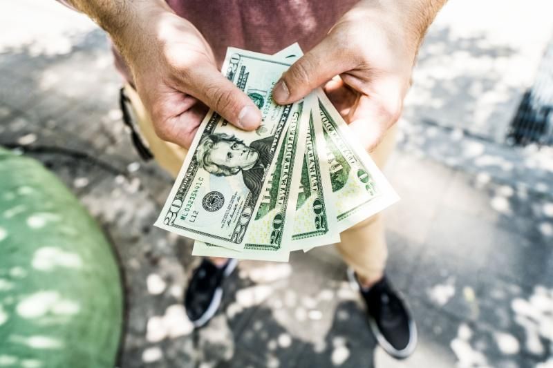 A man is holding a bunch of money in his hands.
