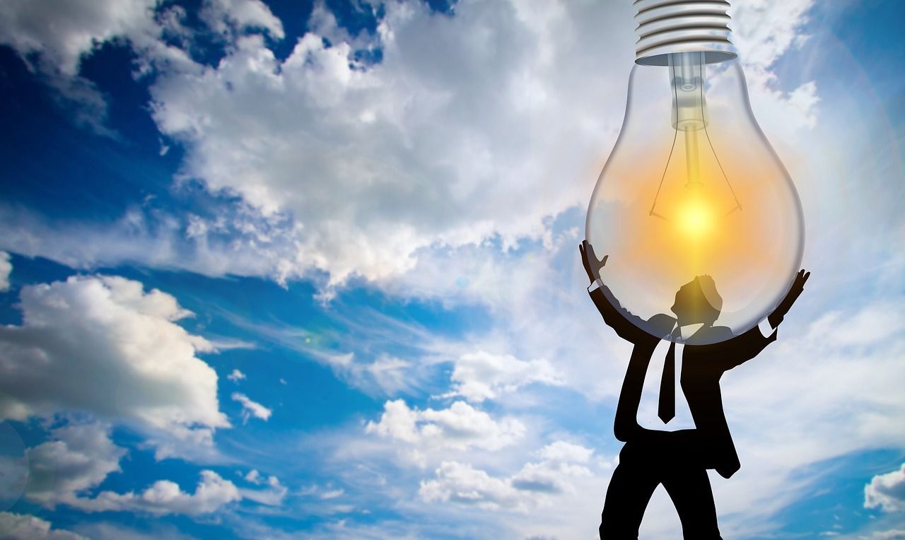 A man in a suit is holding a light bulb in his hands.