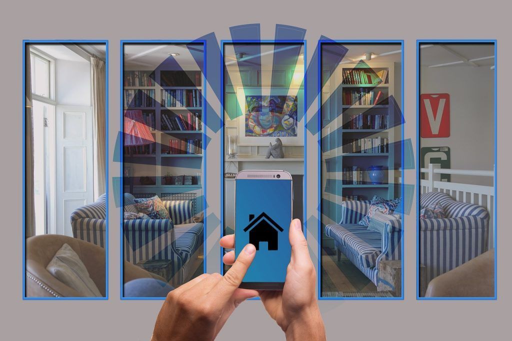 A person is holding a smart phone in front of a living room.
