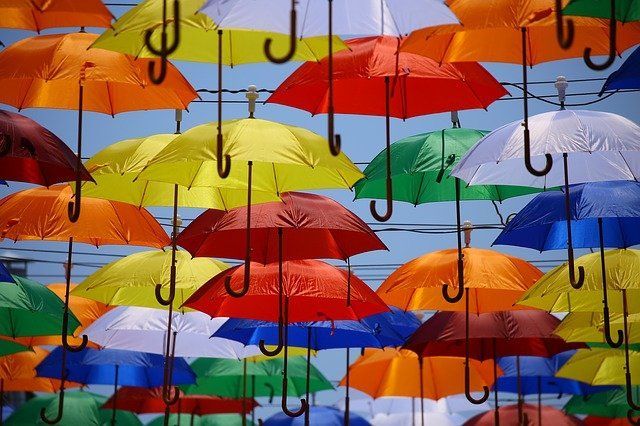 A bunch of colorful umbrellas hanging from a wire