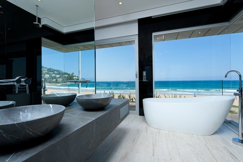 A Bathroom with Two Sinks and A Bathtub with A View of The Ocean — DecoGlaze in Cardiff, NSW